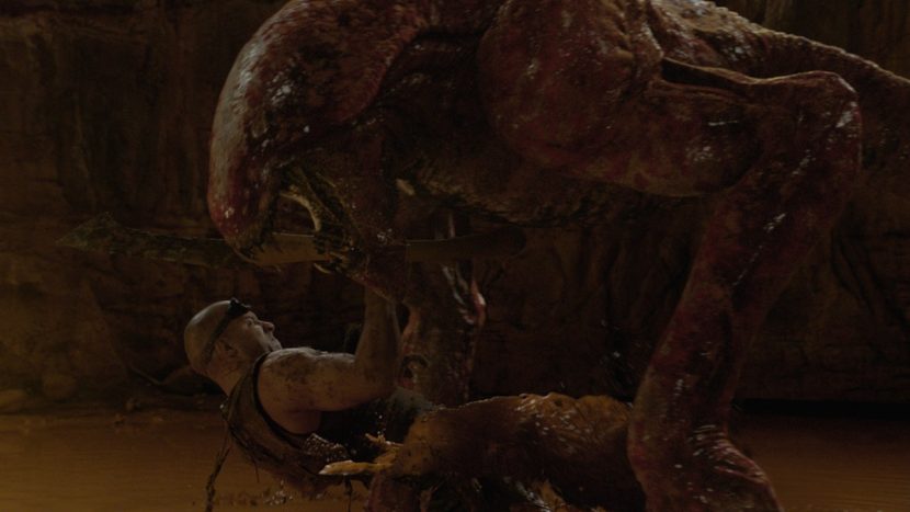 Riddick takes on a large Mud Demon.