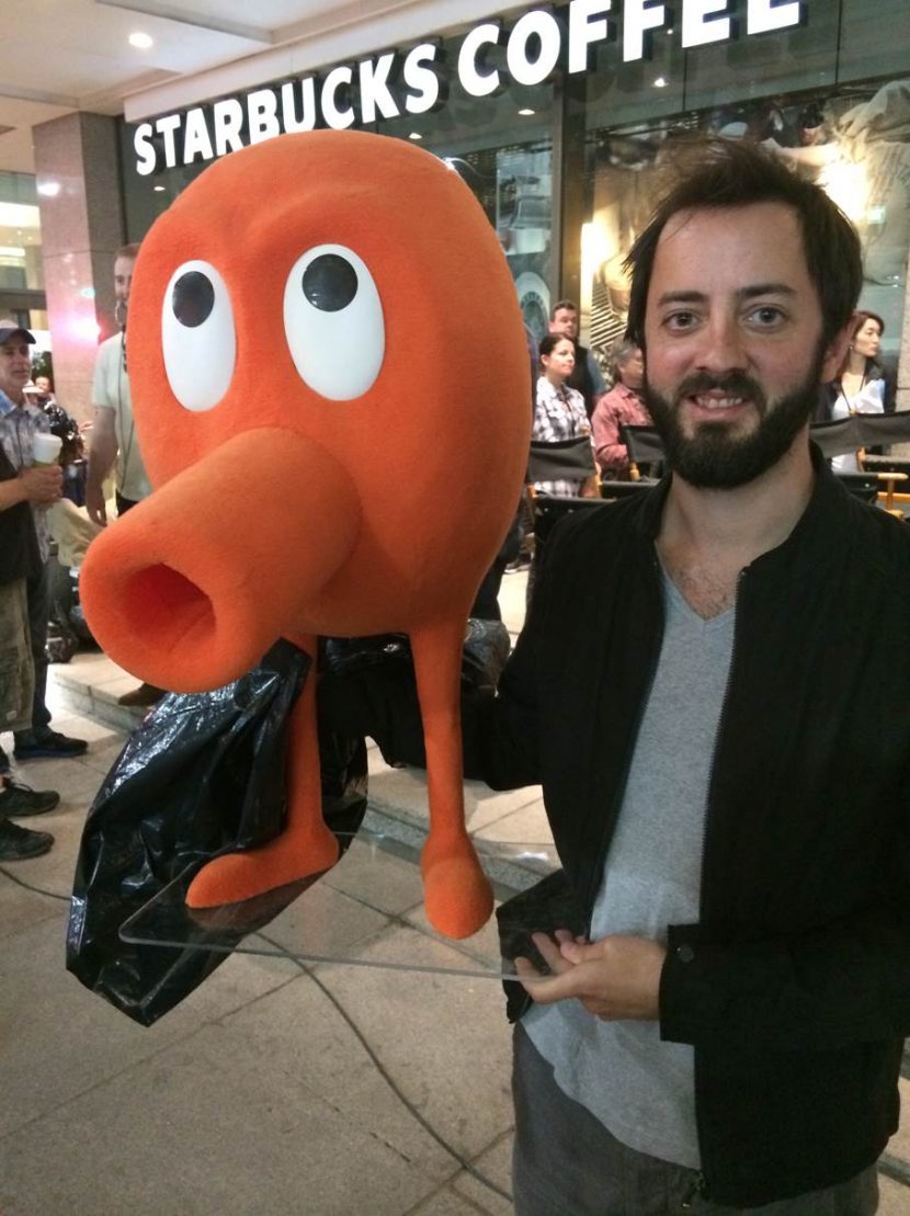 Jean holding Q*Bert, a character from the feature film, during shooting.